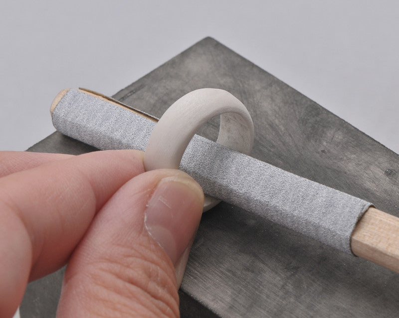 320 grit 3M Self - Adhesive Sandpaper Roll used on a round wooden stick